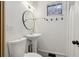 Well-lit bathroom with a pedestal sink, round mirror, and convenient towel hooks by the window at 761 Bellemeade Nw Ave, Atlanta, GA 30318