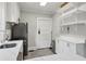 Galley kitchen with white cabinets, stainless steel appliances, and light gray tile floor at 761 Bellemeade Nw Ave, Atlanta, GA 30318