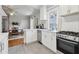 Galley kitchen with stainless appliances and view to dining room with brick fireplace at 761 Bellemeade Nw Ave, Atlanta, GA 30318