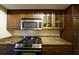 Kitchen showcasing stainless steel oven, granite counters, and wooden cabinets and glass display cabinets at 1013 Canyon Point Cir, Roswell, GA 30076