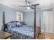 Well-lit bedroom featuring a ceiling fan, a four-post bed frame, and an adjacent window at 1202 Coan Dr, Locust Grove, GA 30248