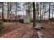 View of the backyard with a storage shed, wooden fence, and mature trees at 4020 Winchester Way, Loganville, GA 30052