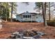 Backyard view of home with an enclosed porch and fire pit; a lovely space for relaxing and entertaining at 4020 Winchester Way, Loganville, GA 30052