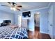 Spacious bedroom with wood floors, ceiling fan, natural light, TV, and walk in closet at 4020 Winchester Way, Loganville, GA 30052