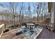 Back porch with wood railing, wood floors, and a table and chairs for outdoor dining and enjoying the view at 218 Sutallee Ridge Ne Ct, White, GA 30184