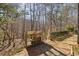 The backyard features a wooden firewood storage shed and a brick-paved area set against a serene wooded backdrop at 218 Sutallee Ridge Ne Ct, White, GA 30184