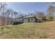 View of the charming home with a well-manicured lawn surrounded by beautiful trees at 218 Sutallee Ridge Ne Ct, White, GA 30184