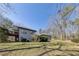 Exterior view from the yard, showcasing a deck, well-kept lawn, mature trees, and the home's architectural style at 218 Sutallee Ridge Ne Ct, White, GA 30184