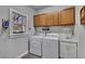 Functional laundry room featuring modern washer and dryer units, sink and storage at 218 Sutallee Ridge Ne Ct, White, GA 30184