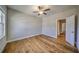 A spacious bedroom with a ceiling fan, hardwood floors, and natural light at 2300 Kate Moore Way, Buford, GA 30518