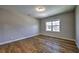 An empty bedroom with hardwood flooring and a window allowing natural light at 2300 Kate Moore Way, Buford, GA 30518