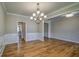 Dining room featuring hardwood floors and wainscoting, with views of the pantry and kitchen at 2300 Kate Moore Way, Buford, GA 30518