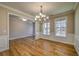 Formal dining room featuring hardwood floors, wainscoting, and a stylish chandelier at 2300 Kate Moore Way, Buford, GA 30518