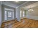 Open foyer area with hardwood flooring, large windows, and a view into the dining room at 2300 Kate Moore Way, Buford, GA 30518