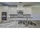 Well-lit kitchen features white cabinets, stainless steel appliances, and gray subway tile backsplash at 2300 Kate Moore Way, Buford, GA 30518