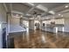 Wide-angle view of living room, kitchen and stairway with hardwood floors and coffered ceiling at 2300 Kate Moore Way, Buford, GA 30518