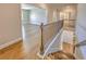 View of staircase featuring hardwood floors, wooden railing, and neutral paint at 2300 Kate Moore Way, Buford, GA 30518