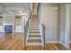 A bright staircase ascends with hardwood floors, flanked by a living room and entryway at 2300 Kate Moore Way, Buford, GA 30518