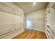 Walk-in closet with hardwood floors and built in closet organizers at 2300 Kate Moore Way, Buford, GA 30518