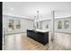 Modern kitchen boasts an island with black cabinets, white countertops, and a stylish light fixture, creating a sleek and inviting space at 3139 Alston Dr, Decatur, GA 30032