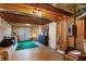 A partially unfinished basement space with exposed ductwork, a concrete floor, and a door leading to the exterior at 7452 Mount Vernon Rd, Lithia Springs, GA 30122