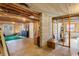 Partially finished basement space with exposed beams, concrete walls, and a doorway leading to the outside at 7452 Mount Vernon Rd, Lithia Springs, GA 30122