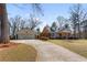 Exterior shot of house with a large driveway leading to a two-car garage and well-manicured front lawn at 7452 Mount Vernon Rd, Lithia Springs, GA 30122