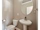 Powder room featuring a pedestal sink, modern faucet, toilet, and oval mirror at 146 Rowan Ave, Alpharetta, GA 30009