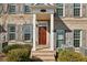 A welcoming brick home featuring a charming entrance with a covered porch and shuttered windows at 146 Rowan Ave, Alpharetta, GA 30009