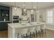 Open-concept kitchen with island seating, stainless appliances, and pendant lights at 146 Rowan Ave, Alpharetta, GA 30009