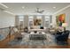Bright living room with hardwood floors, large windows, comfortable seating, and modern art at 146 Rowan Ave, Alpharetta, GA 30009