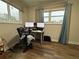 A bedroom with hardwood floors featuring dual computer monitors, a desk, and large windows at 62 Place Fontaine, Lithonia, GA 30038