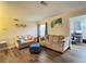 Cozy living room with hardwood floors, neutral-toned furniture, and natural light streaming in through a window at 62 Place Fontaine, Lithonia, GA 30038