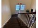 Interior stairwell leading to the exit featuring carpeted steps and white banisters at 62 Place Fontaine, Lithonia, GA 30038