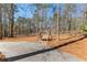 Backyard view featuring a wooden swing under trees, creating a serene outdoor space for relaxation and enjoyment at 105 Leisure Trl, Peachtree City, GA 30269