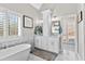 Bright bathroom with a soaking tub, double vanity, marble floors, and modern fixtures at 105 Leisure Trl, Peachtree City, GA 30269