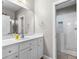 Bathroom with white cabinetry, large mirror, and glass shower with patterned tile floor and built-in shelving at 105 Leisure Trl, Peachtree City, GA 30269