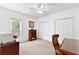 Bedroom features a cozy chair, large window, double closet, ceiling fan, and well-lit space at 105 Leisure Trl, Peachtree City, GA 30269