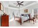 Bright primary bedroom with tray ceilings, a ceiling fan, and large windows for natural light at 105 Leisure Trl, Peachtree City, GA 30269