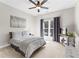 Cozy bedroom with a queen bed, soft gray bedding, and a sunlit window with backyard view at 105 Leisure Trl, Peachtree City, GA 30269