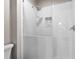 Close up of walk-in shower with white subway tile, glass door, rain shower head, and tiled built-in niche at 105 Leisure Trl, Peachtree City, GA 30269