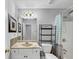 Bathroom with tile floor, granite vanity, shower, and black metal storage shelves at 1098 Berkley Se Dr, Smyrna, GA 30082