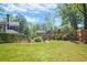 Lush backyard with manicured lawn, a combination of black and wood fencing, and blooming flowers at 2922 Parkridge Ne Dr, Brookhaven, GA 30319