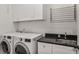 Functional laundry room with modern washer and dryer, sink, and countertop at 2922 Parkridge Ne Dr, Brookhaven, GA 30319