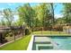 Backyard pool with turf, surrounded by black fencing and lush greenery, perfect for outdoor fun at 2922 Parkridge Ne Dr, Brookhaven, GA 30319