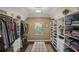 Spacious walk-in closet with custom shelving for clothing and shoes, centered by a cozy upholstered bench at 1907 Haven Park Se Cir, Smyrna, GA 30080