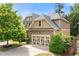 Exterior shows side entry garage of home surrounded by landscaping, mature trees and a blue sky at 1907 Haven Park Se Cir, Smyrna, GA 30080