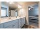 Well lit bathroom featuring double sinks, a large mirror, and wood floors at 4700 Blake Loop, Atlanta, GA 30349