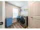 Modern laundry room features wood-look flooring, washer and dryer, and a mini fridge at 4700 Blake Loop, Atlanta, GA 30349