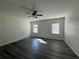 Bright primary bedroom featuring two windows, neutral walls, modern ceiling fan, and stylish flooring at 8620 Blair Ct, Douglasville, GA 30134